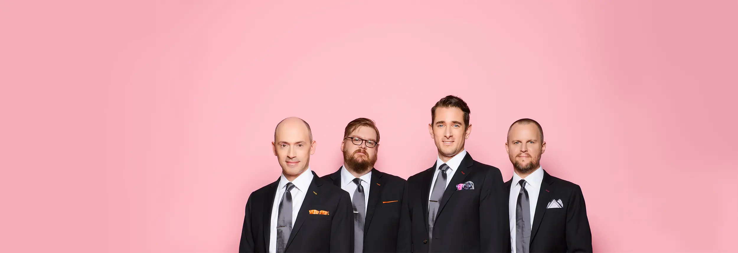 New York Polyphony Members standing against a pink background.