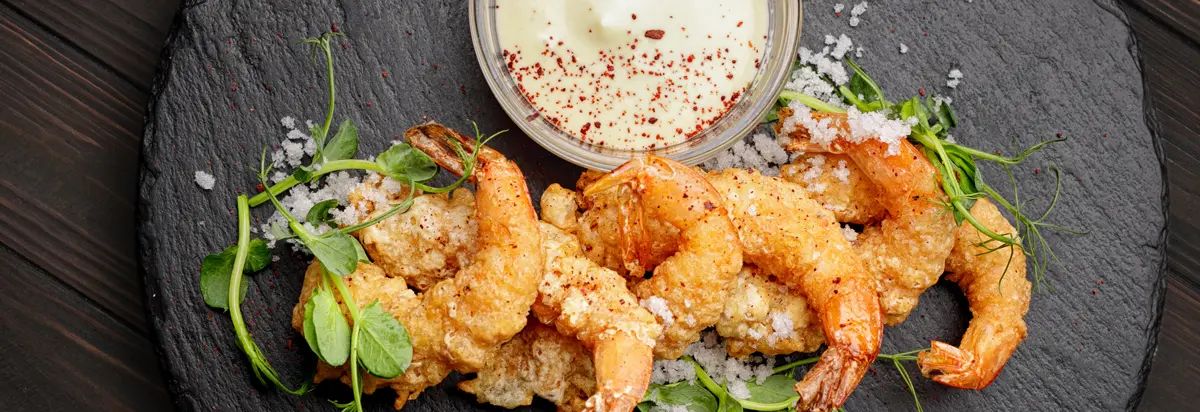 Fried shrimp platter on top of a bed of arugula.