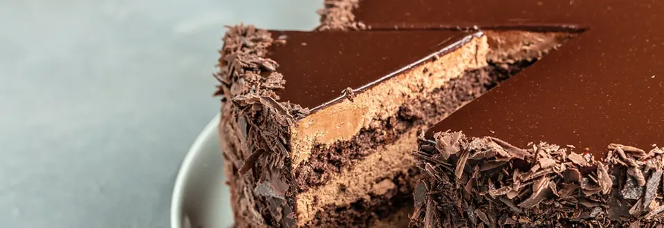 A slice of tasty homemade chocolate cake on plate. Layered chocolate cake tart.
