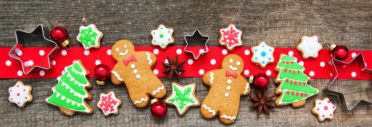 a line up of decorated gingerbread and sugar cookies with star cookie cutters