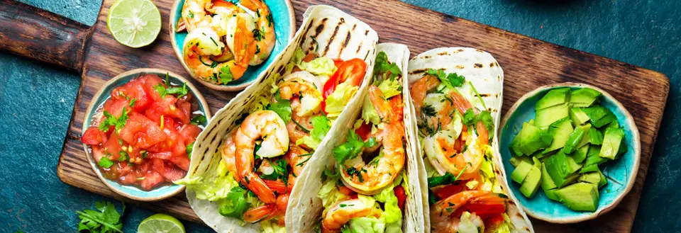 Shrimps tacos with salsa, vegetables and avocado. Mexican food.
